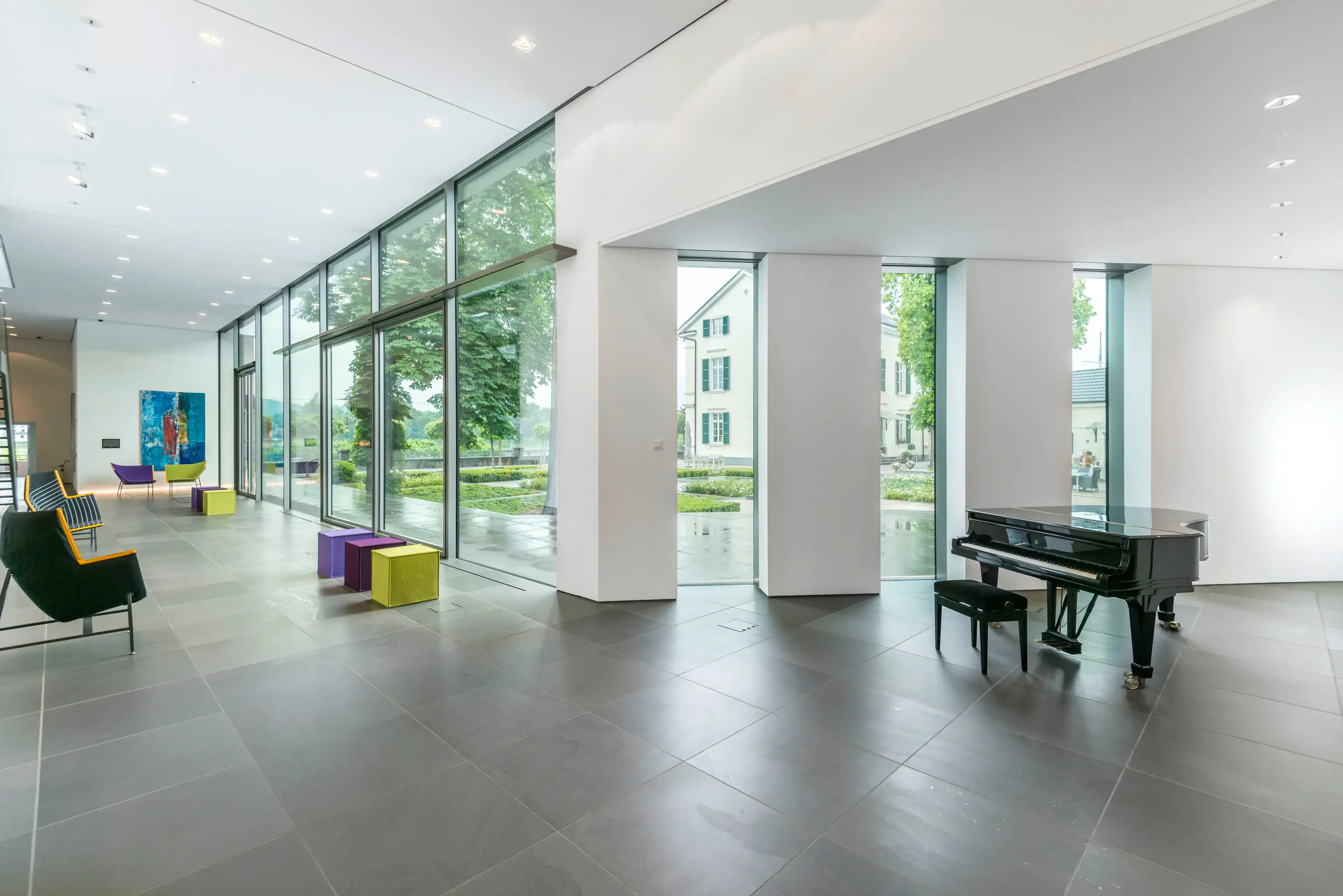 Helle Halle mit Glasfront und Konzertflügel