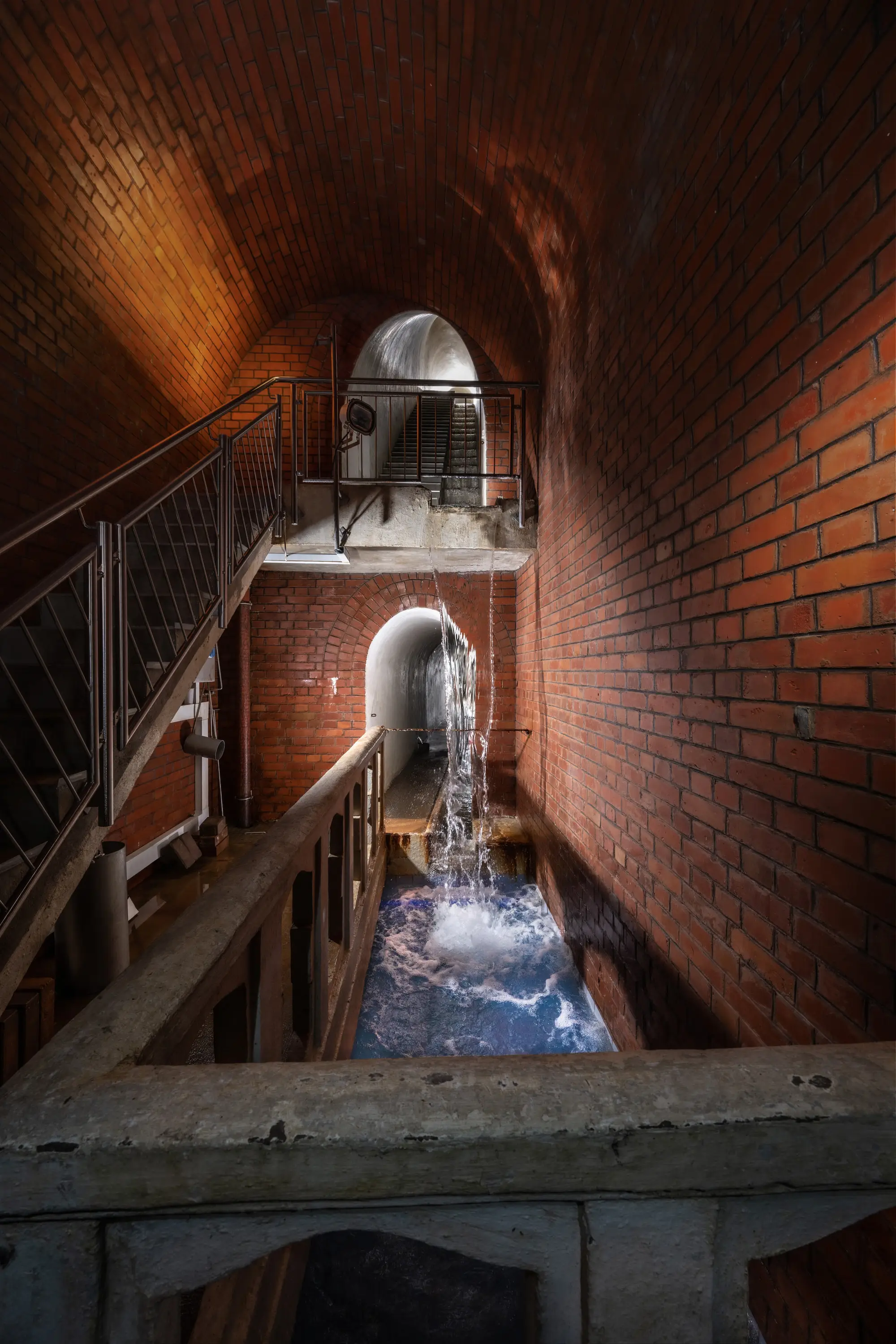 Wasserbecken und Treppen im Backsteingewölbe des Wasserwerks Würzburg-Zell