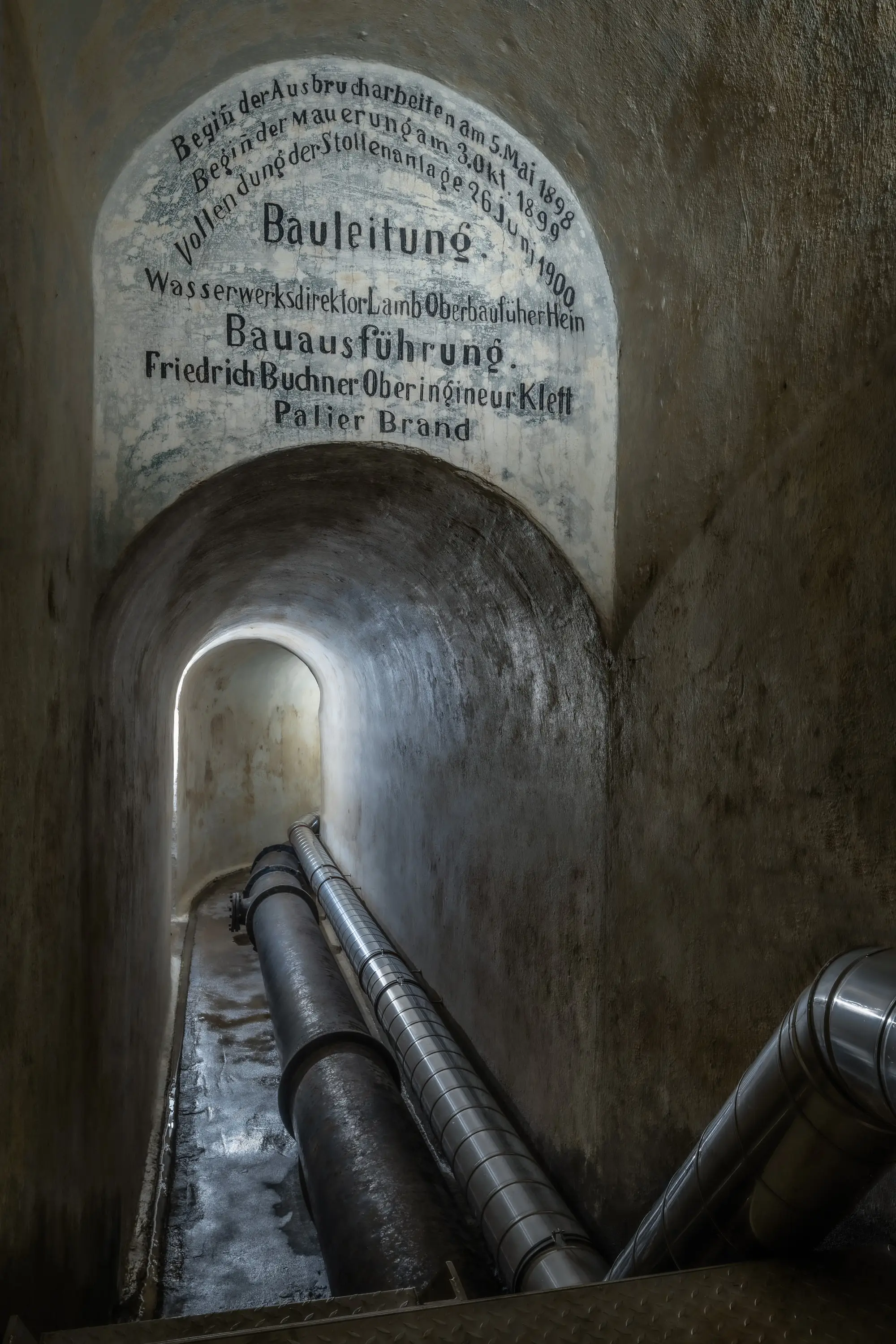Gang mit Rohrleitungen und historischer Inschrift im Wasserwerk Würzburg-Zell