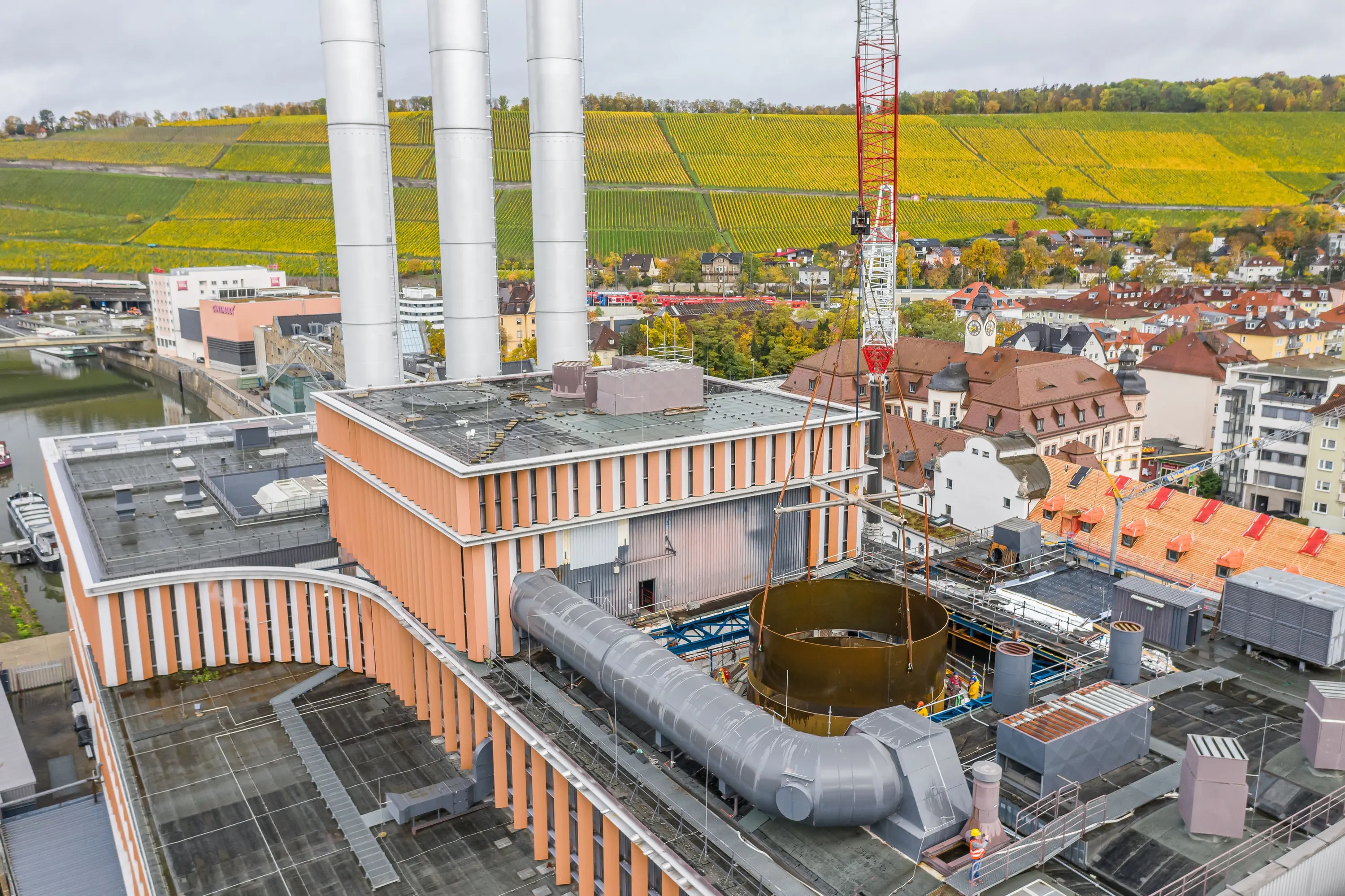 Baustelle des Heizkraftwerks Würzburg aus der Luft, dahinter Weinberge