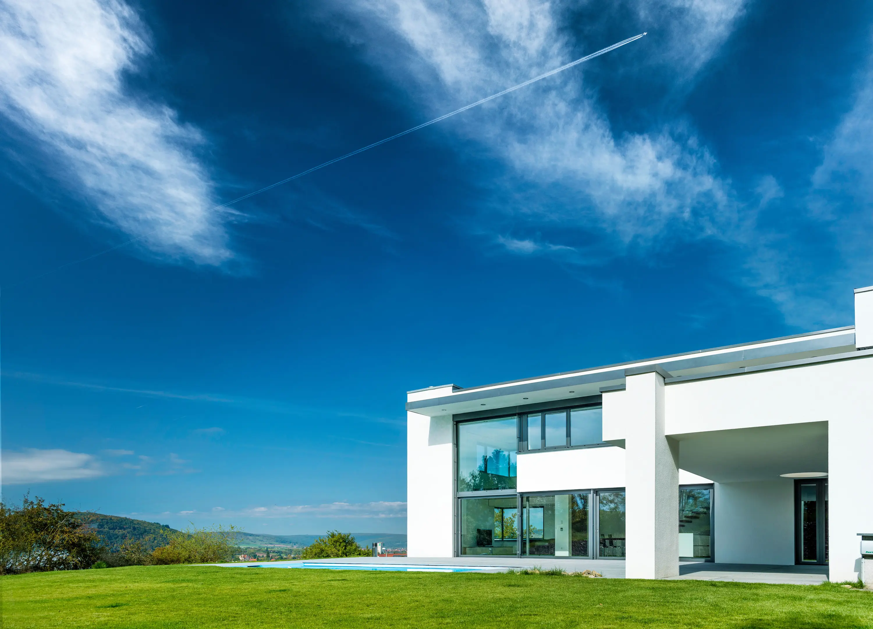 Moderne Villa mit großen Glasflächen unter blauem Himmel
