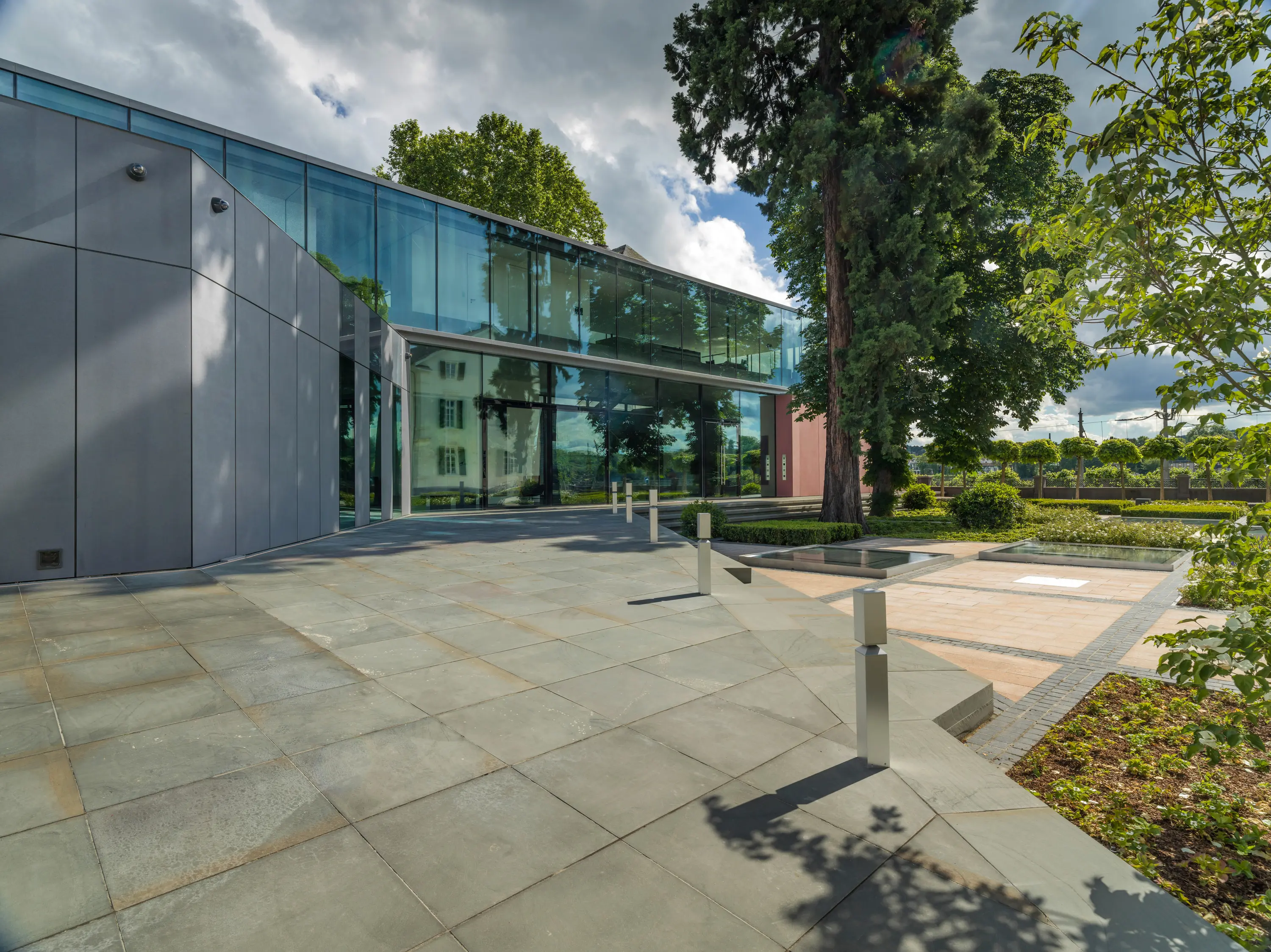 Gebäude mit Glasfassade und gestaltetem Garten mit Wasserbecken