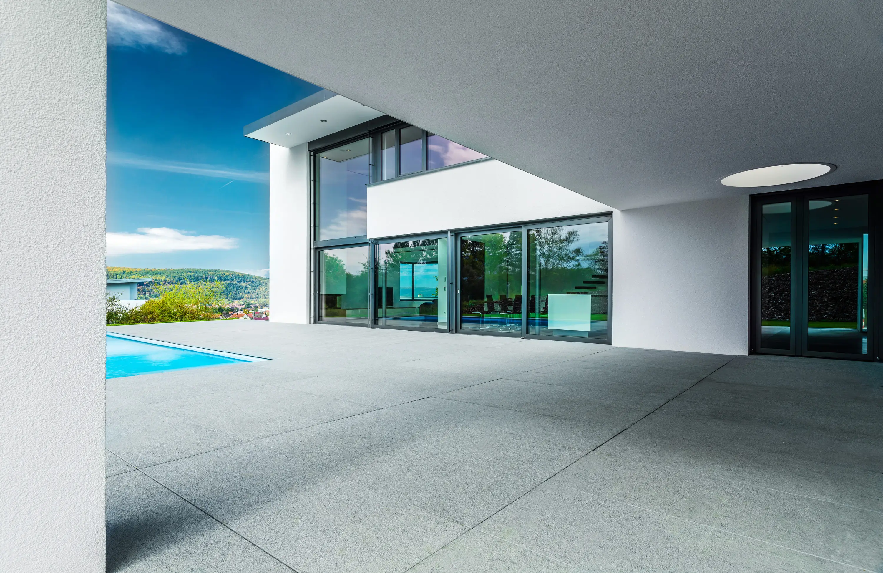 Überdachte Terrasse mit Pool und Blick ins Tal, moderne Villa