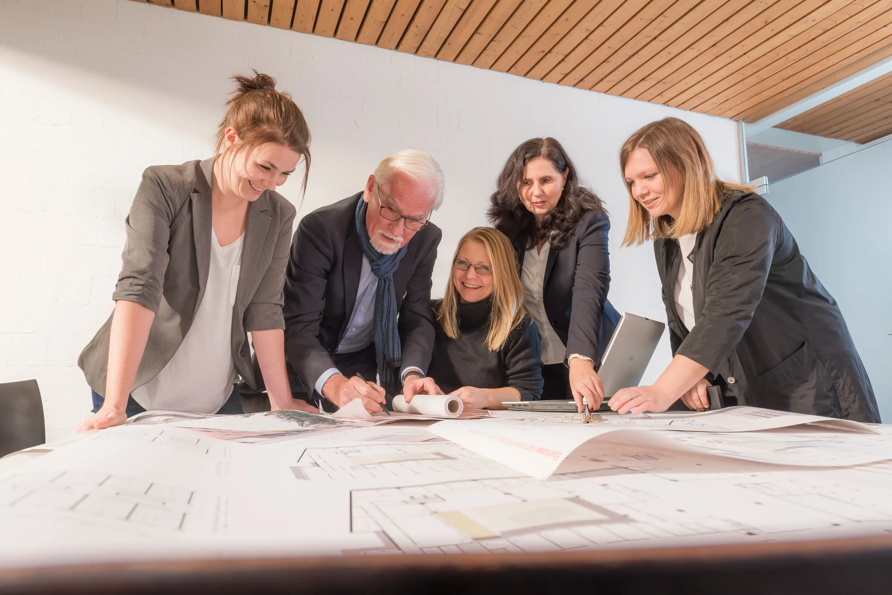 Architektenteam bespricht Pläne am Tisch