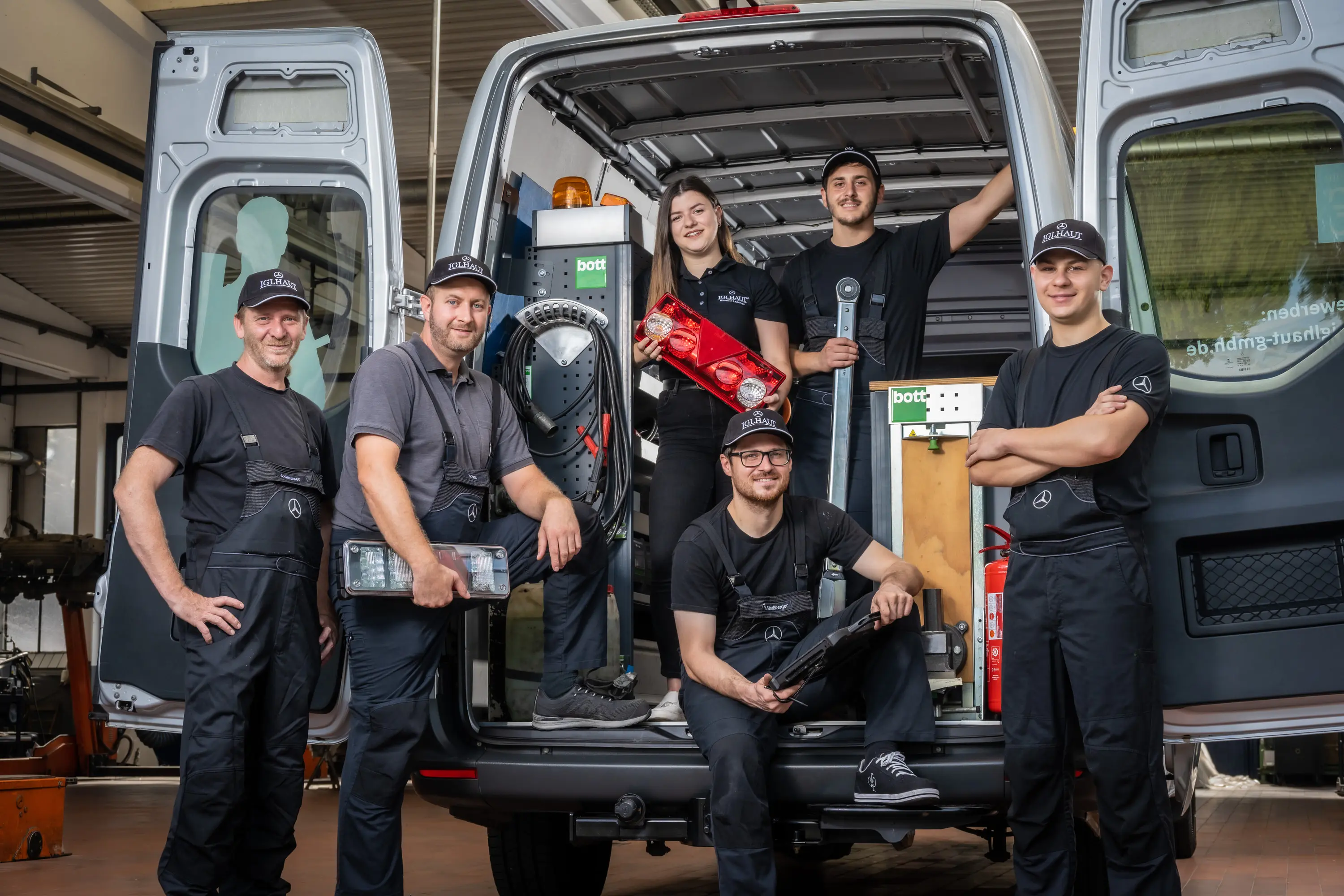 Werkstattteam von Iglhaut mit Werkzeug vor einem offenen Transporter