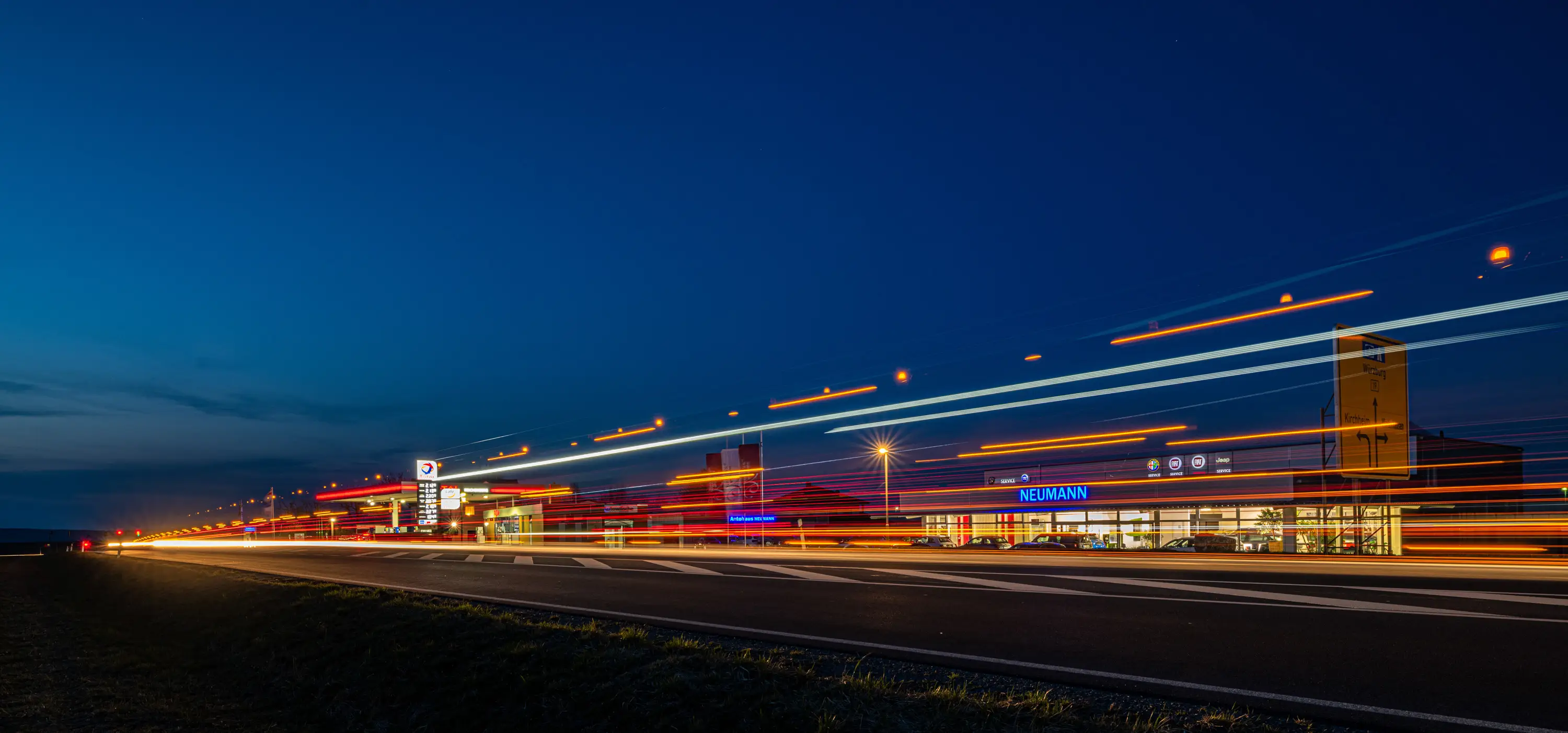Lichtspuren auf der Straße am Autohaus Neumann zur blauen Stunde