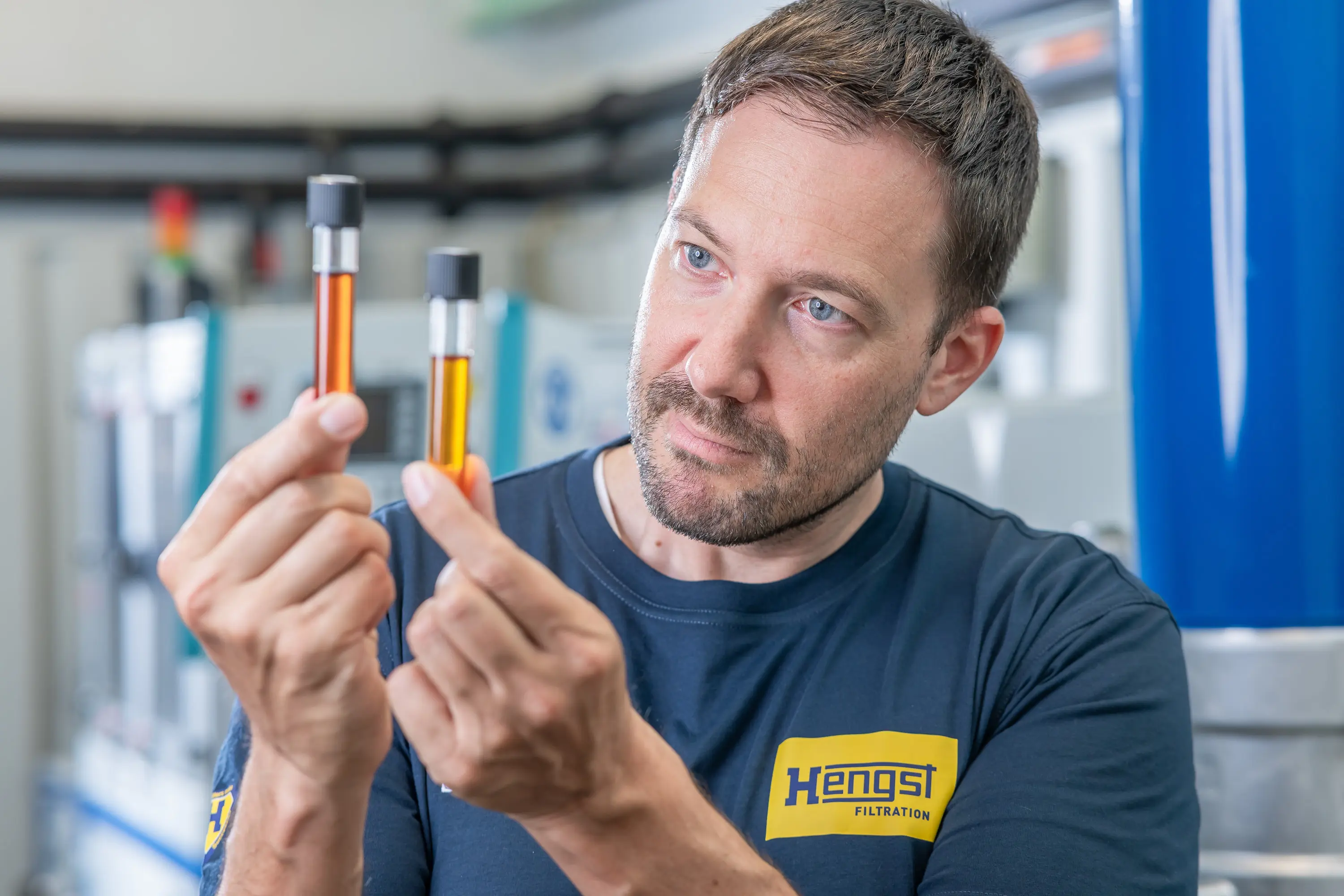 Mitarbeiter von Hengst Filtration prüft zwei Ölproben im Labor