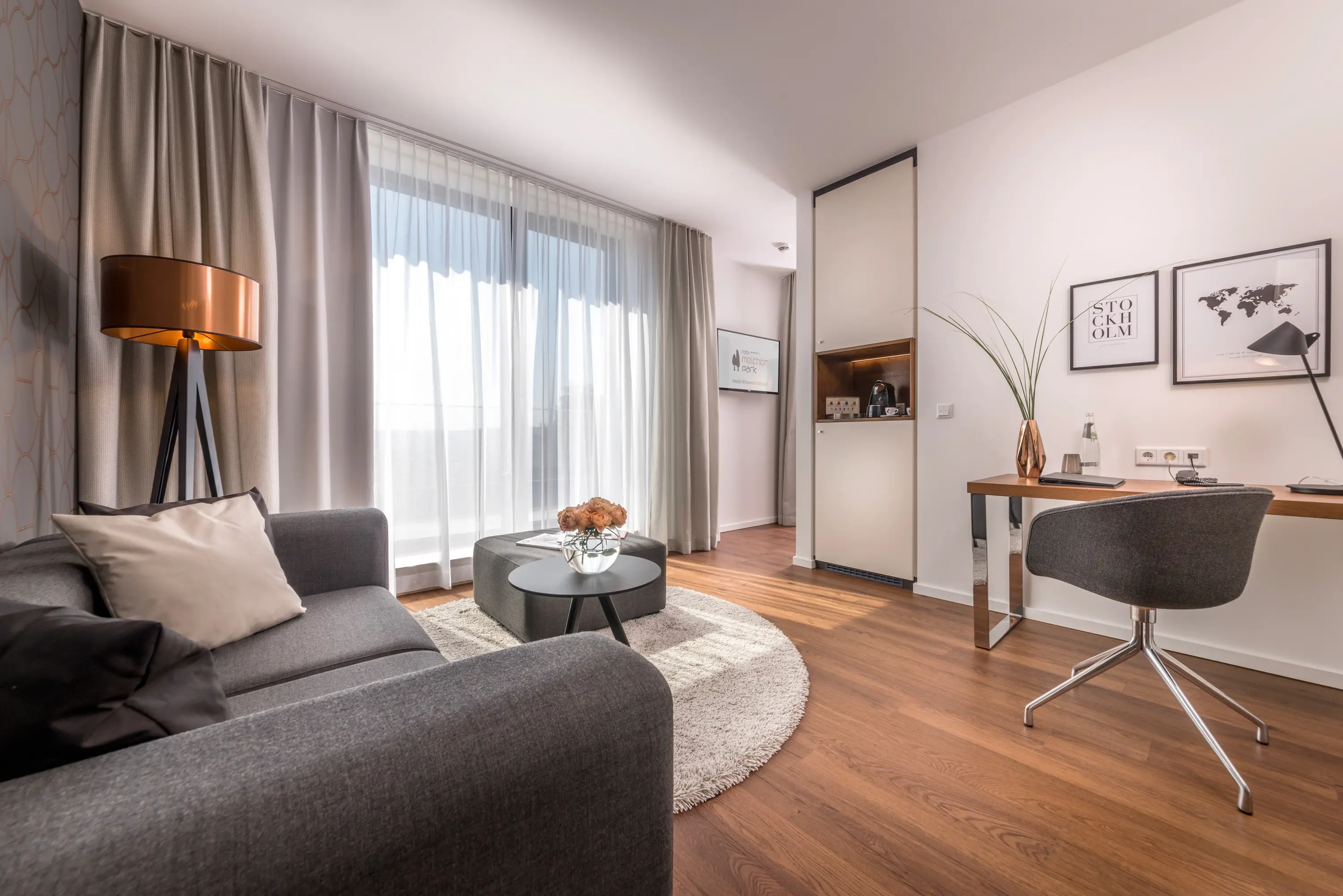 Hotelzimmer mit Sitzecke und bodentiefen Fenstern, Hotel Melchiorpark Würzburg