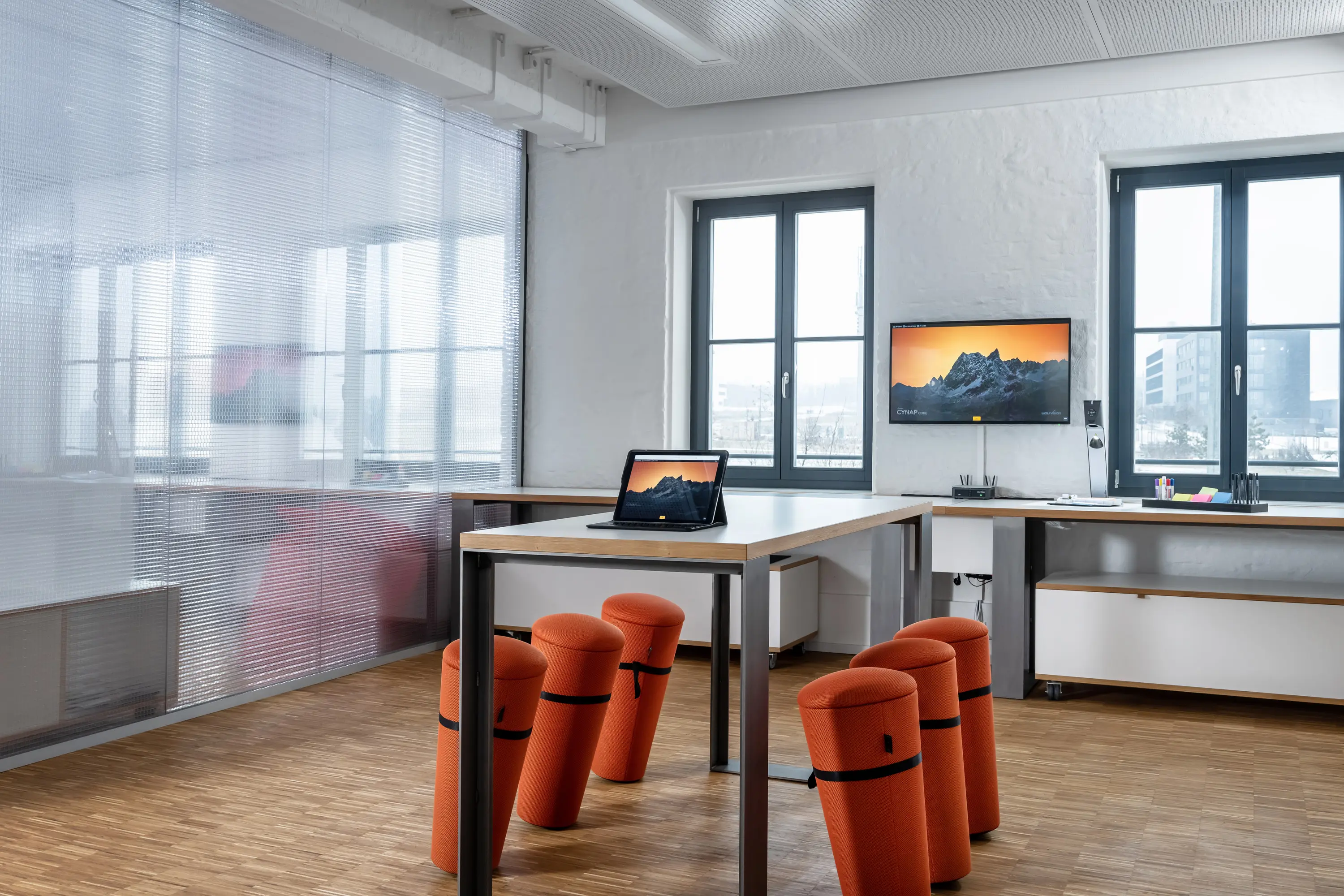 Arbeitsplätze mit orangefarbenen Hockern und Bildschirmen im ZDI Mainfranken