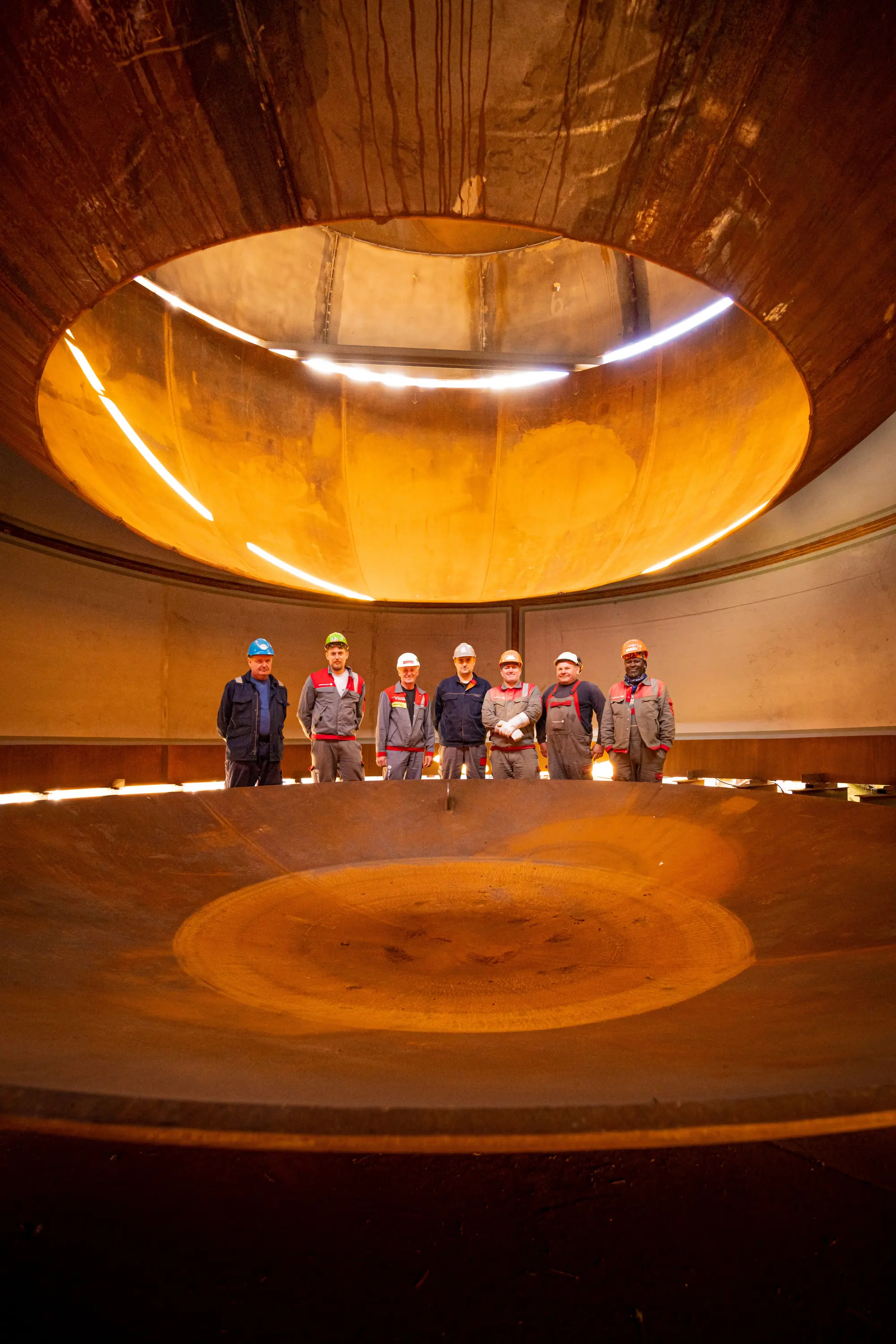Bauteam steht im Inneren eines großen Stahlbehälters, Heizkraftwerk Würzburg